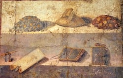 Moedas e material romano para escrita e leitura